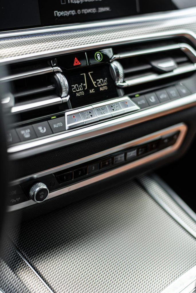 Close-up of a luxury car dashboard featuring climate control and metallic textures.